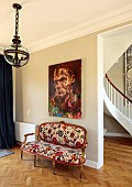 PRIVATE GARDEN, DEDHAM VALE, SUFFOLK: BERGERE SOFA IN HALLWAY, UPHOLSTERED IN ARTEMIS BY HOUSE OF HACKNEY, CURVED STAIRCASE, PAINTING BY ANDREW SALGADO