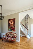 PRIVATE GARDEN, DEDHAM VALE, SUFFOLK: BERGERE SOFA IN HALLWAY, UPHOLSTERED IN ARTEMIS BY HOUSE OF HACKNEY, CURVED STAIRCASE, STONE BUST OF ANTONIUS, PAINTING BY ANDREW SALGADO