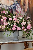 PRIVATE GARDEN, DEDHAM VALE, SUFFOLK: DINING ROOM, FOLIAGE AND PINK ROSES ARRABNGED IN A GRECIAN STYLE URN, PAINTING THE DUCHESS BY MANDY RACINE