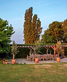 PRIVATE GARDEN, DEDHAM VALE, SUFFOLK: LAWN, PERGOLA, COVERED SEATING, DINING AREA, TABLE, CHAIRS, HEDGES, HEDGING