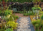 HAMPTON COURT 2023: DESIGNER LUCY TAYLOR, TRADITIONAL TOWNHOUSE GARDEN, STONE PATH, METAL SEATS, CONTAINERS, MULTISTEMMED PRUNUS SERRULA, BEECH HEDGES, HEDGING