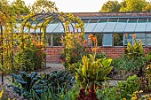 MORTON HALL GARDENS, WORCESTERSHIRE: JULY, KICHEN GARDENS, POTAGER, VEGETABLE, CONTAINER, CABBAGES, ARCH, CANNA TROPICANA GOLD