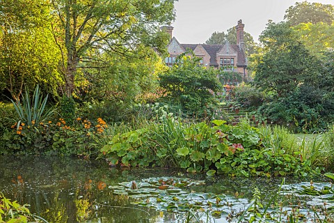 STOCKCROSS_HOUSE_BERKSHIRE_VIEW_TO_HOUSE_ACROSS_POND_LAKE_WATER_SEPTEMBER_WATERLILIES_WATER_LILIES