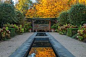 THE OLD VICARAGE, WORMINGFORD, ESSEX: DESIGNER JEREMY ALLEN: NOVEMBER, FALL, AUTUMN, YEW HEDGES, HEDGING, RILL, CLIPPED PYRUS SALICIFOLIA, HYDRANGEA ANNABELLE, SEAT, REFLECTIONS