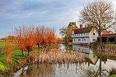 COLUMBINE HALL, SUFFOLK: THE HALL SEEN ACROSS THE MOAT, MARCH, REEDS, WILLOWS, REFLECTED, REFLECTIONS, LANDSCAPE