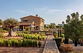 PRIVATE GARDEN ALARO, MALLORCA, DESIGNED BY MASHAMBA DESIGN: APRIL, STONE WALL, STIPA TENUISSIMA, OLIVE TREE