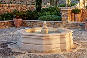 PRIVATE GARDEN ALARO, MALLORCA, DESIGNED BY MASHAMBA DESIGN: COURTYARD, FOUNTAIN, WALL, TERRACOTTA CONTAINERS, DECORATIVE COBBLED FLOOR