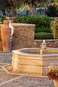 PRIVATE GARDEN ALARO, MALLORCA, DESIGNED BY MASHAMBA DESIGN: COURTYARD, FOUNTAIN, WALL, TERRACOTTA CONTAINERS, DECORATIVE COBBLED FLOOR