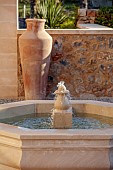 PRIVATE GARDEN ALARO, MALLORCA, DESIGNED BY MASHAMBA DESIGN: COURTYARD, FOUNTAIN, WALL, TERRACOTTA CONTAINERS, DECORATIVE COBBLED FLOOR