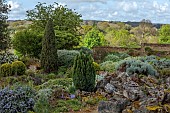 DODDINGTON PLACE, KENT: APRIL, SPRING, THE ROCK GARDEN, ROSEMARY, WALLS, BORROWED LANDSCAPE