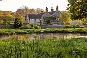 CAISSON GARDEN, SOMERSET: ROUND POND AND TOPIARY MEADOW IN FRONT OF THE HOUSE, APRIL, SPRING, WATER, POOL, CLIPPED BOX BALLS