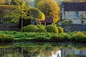 CAISSON GARDEN, SOMERSET: ROUND POND AND TOPIARY MEADOW IN FRONT OF THE HOUSE, APRIL, SPRING, WATER, POOL, CLIPPED BOX BALLS