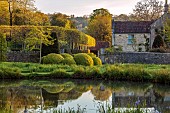 CAISSON GARDEN, SOMERSET: ROUND POND AND TOPIARY MEADOW IN FRONT OF THE HOUSE, APRIL, SPRING, WATER, POOL, CLIPPED BOX BALLS