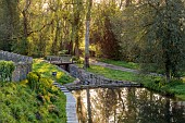 CAISSON GARDEN, SOMERSET: VIEW DOWN TO THE POUND, POND WITH ENGLISH OAK BOARDWALK, DECK, EUPHORBIA PALUSTRIS, LAMIUM ORVALA, BOAT, BRIDGE OVER CANAL