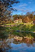 CAISSON GARDEN, SOMERSET: CAISSON HOUSE SEEN FROM THE POUND, POND WITH ENGLISH OAK BOARDWALK, DECK, EUPHORBIA PALUSTRIS, LAMIUM ORVALA, REFLECTIONS, REFLECTED