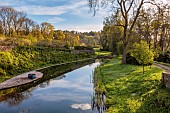 CAISSON GARDEN, SOMERSET: VIEW DOWN ONTO THE POUND, POND WITH ENGLISH OAK BOARDWALK, DECK, BOAT, EUPHORBIA PALUSTRIS, LAMIUM ORVALA, REFLECTIONS, REFLECTED