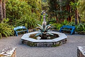 TRESCO ABBEY GARDEN, ISLES OF SCILLY: MAY, SPRING, THE MEDITERRANEAN GARDEN, BLUE WOODEN SEATS, BENCHES, COPPER AGAVE FOUNTAIN