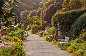 TRESCO ABBEY GARDEN, ISLES OF SCILLY: MAY, SPRING, VIEW ALONG THE TOP TERRACE, PATH, BENCH