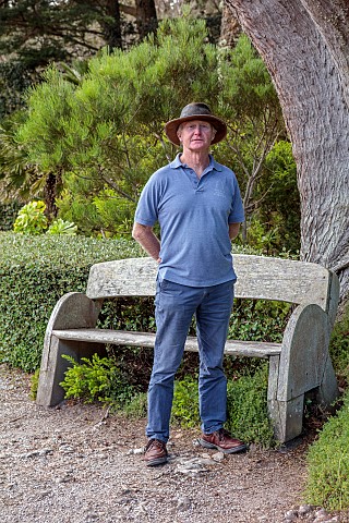 TRESCO_ABBEY_GARDEN_ISLES_OF_SCILLY_MAY_SPRING_PATH_HEAD_GARDENER_ANDREW_LAWSON_BESIDE_A_CUPRESSUS_M
