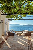 KOULOURA, CORFU, GREECE: DESIGNER PAUL BANGAY: SEA TERRACE, SEATS, TABLE, VINE, PERGOLA
