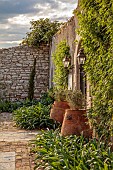 KOULOURA, CORFU, GREECE: DESIGNER PAUL BANGAY: COURTYARD, LAMPS, TERRACOTTA CONTAINERS, WALLS