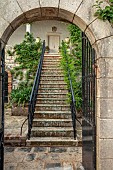 KOULOURA, CORFU, GREECE: DESIGNER PAUL BANGAY: COURTYARD STEPS SEEN THROUGH ARCHWAY