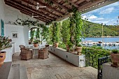 KOULOURA, CORFU, GREECE: DESIGNER PAUL BANGAY: TERRACE, TABLE, CHAIRS, MIRROR, HARBOUR