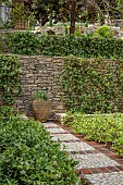 KOULOURA, CORFU, GREECE: DESIGNER PAUL BANGAY: COBBLE FLOORING, PATH, TERRACOTTA CONTAINER, STAR JASMINE, TRACHELOSPERMUM JASMINOIDES, WALL