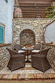 KOULOURA, CORFU, GREECE: DESIGNER PAUL BANGAY: PATIO, COURTYARD, DRIFTWOOD, BLUE SHUTTERS, CHAIRS, TABLE, WALLS, OUTDOOR DINING