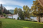 KOULOURA, CORFU, GREECE: DESIGNER PAUL BANGAY: LAWN, TERRACING, WALLS, TERRACOTTA CONTAINERS, CHURCH, BORROWED LANDSCAPE