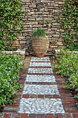 KOULOURA, CORFU, GREECE: DESIGNER PAUL BANGAY: COBBLE FLOORING, PATH, TERRACOTTA CONTAINER, STAR JASMINE, TRACHELOSPERMUM JASMINOIDES, WALL