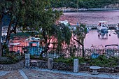 KOULOURA, CORFU, GREECE: DESIGNER PAUL BANGAY: THE COURTYARD AND HARBOUR AT DUSK, EVENING LIGHT