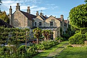 CAISSON GARDEN, SOMERSET: THE KITCHEN TERRACE, STONE PATH, MORUS ALBA TREES, ESPALIERED MALUS EVERESTE TREES, IRIS