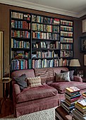PRIORS MARSTON, WARWICKSHIRE, THE MANOR HOUSE: THE LIBRARY IN CHOCOLATE BROWN, BOOKCASE, MAROON SOFA