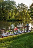 PRIORS MARSTON, WARWICKSHIRE, THE MANOR HOUSE: LONG WOODEN TABLE SET FOR DINNER ON BALCONY BESIDE THE LAKE, MAY