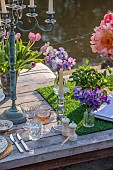 PRIORS MARSTON, WARWICKSHIRE, THE MANOR HOUSE: LONG WOODEN TABLE SET FOR DINNER ON BALCONY BESIDE THE LAKE, MAY