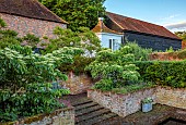 THE MANOR HOUSE, BLEDLOW, BUCKINGHAMSHIRE: MAY, 18TH CENTURY GRANARY ON STADDLE STONES, CORNUS CONTROVERSA PAGODA, STEPS, WALLS