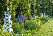 OLD BLADBEAN STUD GARDENS, KENT: JUNE, MIRRORED BORDERS, LAWN, STONE SEAT, OBELISKS, DELPHINIUMS