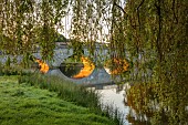 COTTESBROOKE HALL AND GARDENS, NORTHAMPTONSHIRE: THE MITCHELL BRIDGE, WATER, LAKE, SUNRISE, JUNE
