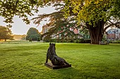 COTTESBROOKE HALL AND GARDENS, NORTHAMPTONSHIRE: JUNE, DAWN, SUNRISE, THE WEST FRONT, LAWN, PARKLAND, STONE STATUE OF WILD BOAR