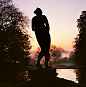 STATUE SILHOUETTED AGAINST THE DAWN SKY. ROUSHAM LANDSCAPE GARDEN  OXFORDSHIRE ( AS 2079)