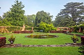 COTTESBROOKE HALL AND GARDENS, NORTHAMPTONSHIRE: DAWN, SUNRISE, THE POOL GARDEN, FOUNTAIN, POND, WATER, LAWN, CEDAR OF LEBANON, COPPER BEECH HEDGE, WALL, WALLED