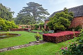 COTTESBROOKE HALL AND GARDENS, NORTHAMPTONSHIRE: DAWN, SUNRISE, THE POOL GARDEN, FOUNTAIN, POND, WATER, LAWN, CEDAR OF LEBANON, COPPER BEECH HEDGE, WALL, WALLED