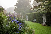 COTTESBROOKE HALL AND GARDENS, NORTHAMPTONSHIRE: STATUE WALK, DAWN, BORDERS, PHLOX PANICULATA COOL OF THE EVENING, DELPHINIUN PINK RUFFLES, VERONICASTRUM VIRGINICUM ALBUM