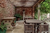 COTTESBROOKE HALL AND GARDENS, NORTHAMPTONSHIRE: THE PINE COURT, WOODEN TABLES, CHAIRS, STATUE, FERNS IN CONTAINERS, PERGOLA