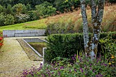 JUNE BLAKES GARDEN, IRELAND: BLACK REFLECTING POOL, RUSTED STEEL EDGING, PEBBLES, SEAT, BENCH
