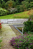 JUNE BLAKES GARDEN, IRELAND: BLACK REFLECTING POOL, RUSTED STEEL EDGING, PEBBLES, SEAT, BENCH