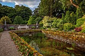 PLAS CADNANT, WALES: POND, POOL, JULY, WATER, BENCH, SEAT, CORNUS CONTRAVERSA VARIEGATA, WALL