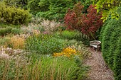 KNOLL GARDENS, DORSET: SEPTEMBER, GRASSES, THE DRAGON GARDEN, RUDBECKIA GOLDSTURM, PENNISETUM, WOODEN BENCH, SEAT