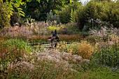 KNOLL GARDENS, DORSET: SEPTEMBER, GRASSES, THE DRAGON GARDEN, POND, POOL, WATER, SCULPTURE, FOUNTAIN